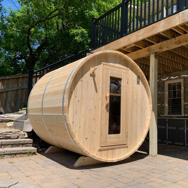 Harmony 4 Person Outdoor Barrel Sauna surrounded by lush greenery and natural beauty