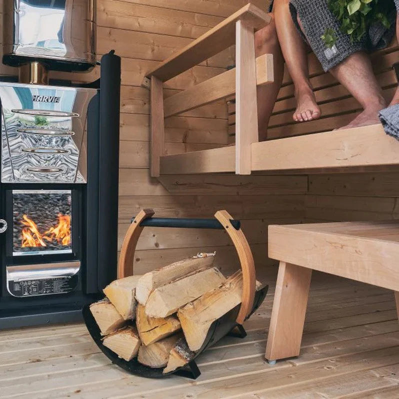 The Harvia PRO Series 31kW Sauna Wood Sauna Stove Pro 36 installed in a traditional Finnish sauna with stone walls and wooden benches